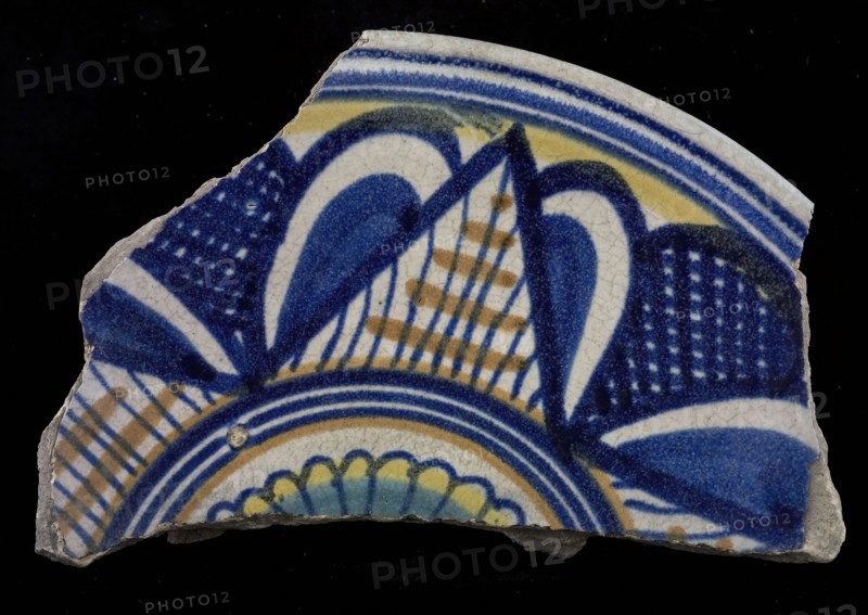 Fragment majolica dish, yellow, orange, green and blue on white, star-shaped decor, with leaf motifs in between, rosette in the