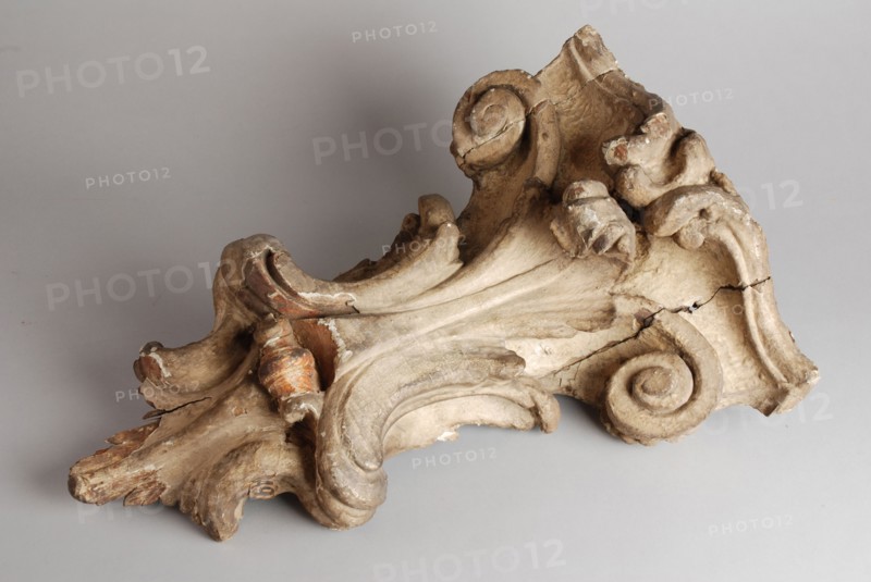 Carved wooden console from the façade of house, console building element carvings sculpture visual material wood gypsum paint