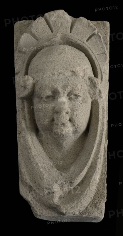 Keystone with gable head, female head with cap, keystone gable ornament building component limestone stone, sculpted Above wider