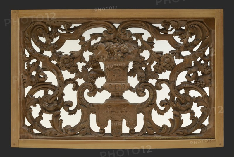 Skylight with an antique vase of wood carved in wood, surrounded by leaves, flowers and garlands, cutting window toplight