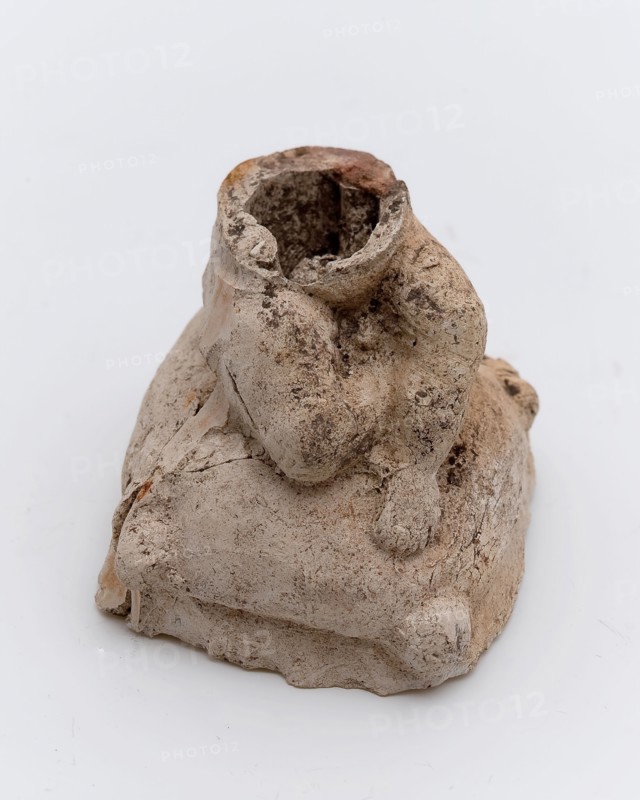 Part of pipe image, representing cushion with sitting figure, sculpture visual material soil finds clay, in mold formed baked