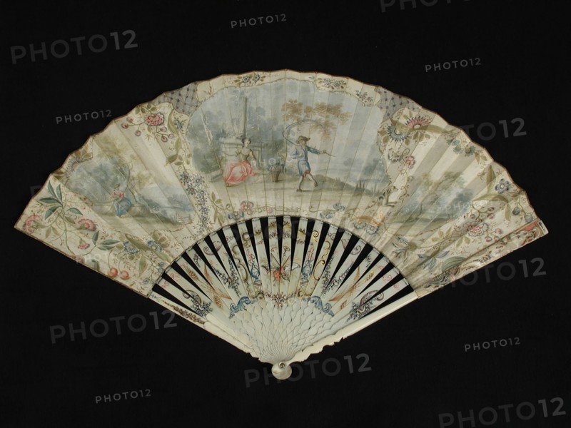 Folding fan with carved and painted ivory frame, both front and rear painted parchment leaf with lady and lord in landscape