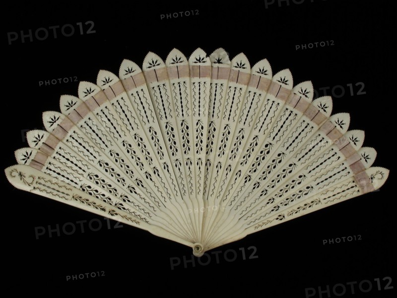 Brisé fan, leaf and legs of cut bone with stylized tendril motifs, briselint of lilac satin, wiséwaaier range clothing