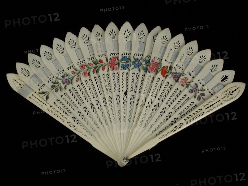 Brisé fan, leaves and legs in carved ivory in stylized motifs, light blue silk briselint, painted on top edge with floral motifs