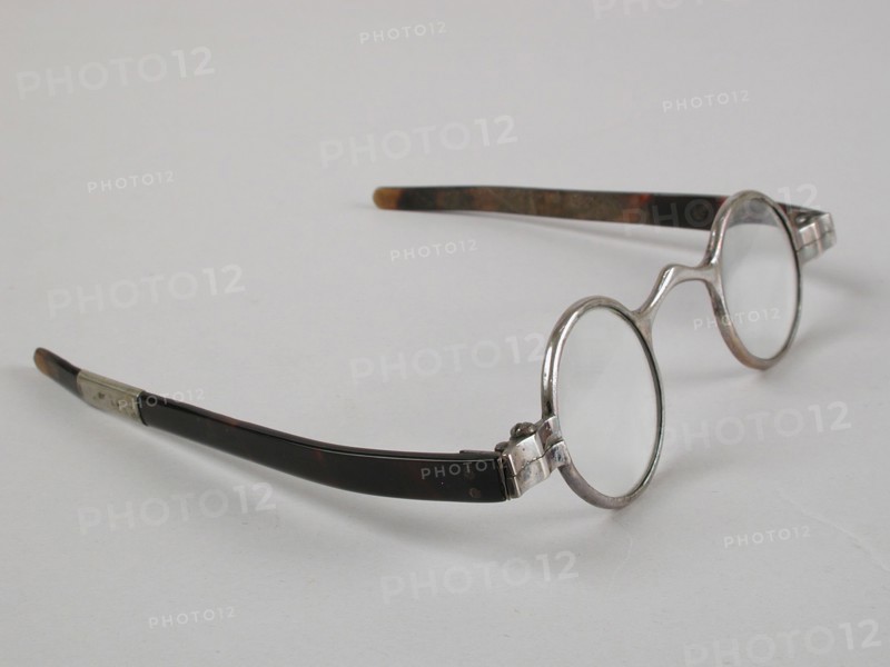 Glasses with round lenses on strength, silver-colored metal frame and short flat feathers of turtle, children's glasses