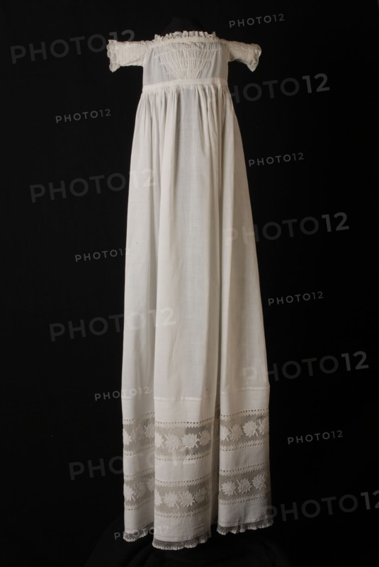 Long christening dress of fine white cotton, square neckline, bodice with smocking, hem edge with white embroidery and tulle
