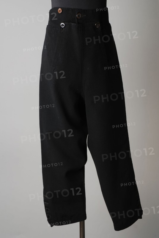 Breeches of black cloth, flap closure on the lap, buttons along the bottom of the leg, part of boy's suit, shorts pants suit