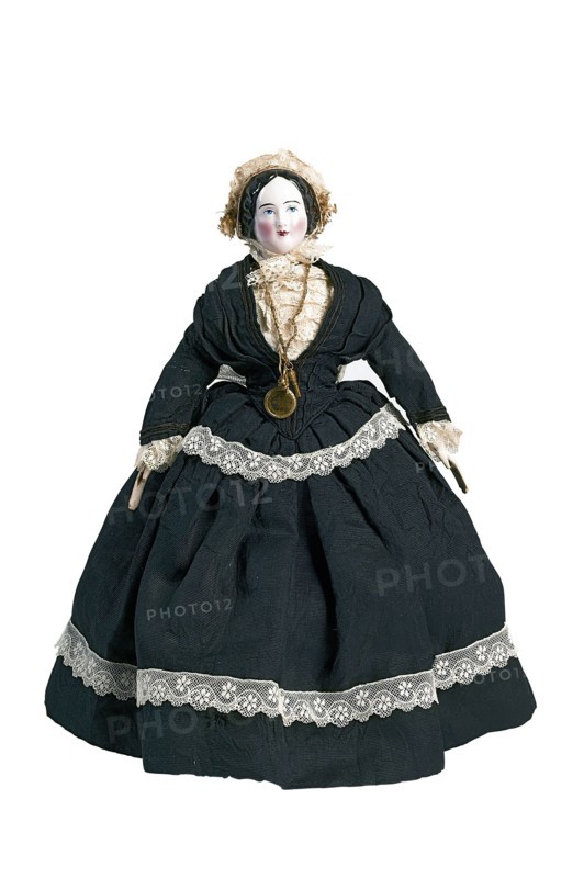 mw. Andres-Van Embden, Dollhouse doll, painted porcelain face with pink complexion, wooden arms, fabric body and legs, dressed