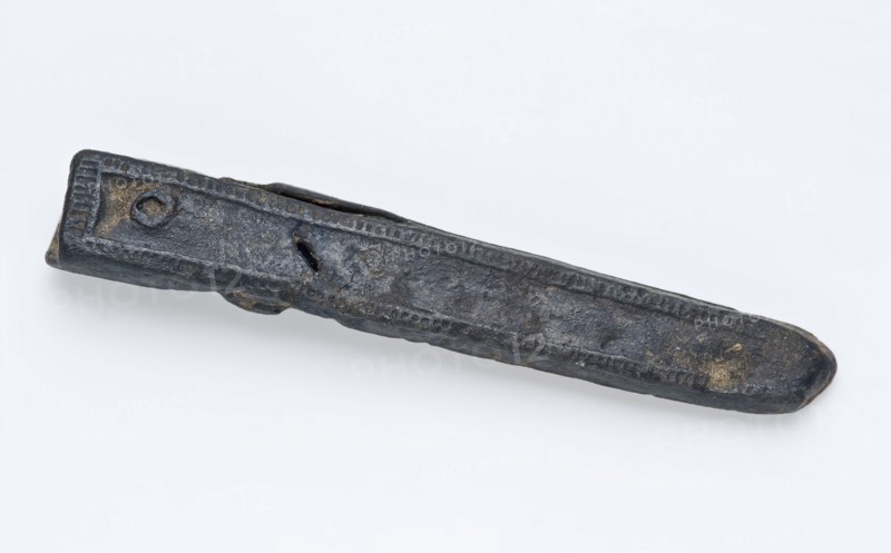 Narrow pewter belt tongue delineated with thin edge shading, fitting belt clothing accessory clothing soil find tin metal