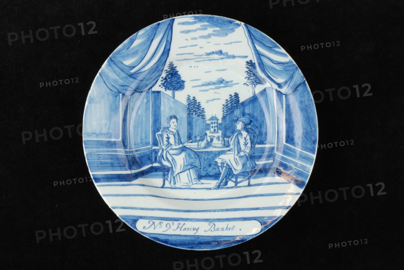 Manufacturer: De Porceleyne Bijl, Series of twelve plates with blue herring industry scenes: No 9. 't Haring banquet, plate