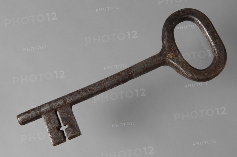 Iron key with oval eye, elongated solid key handle and simple cruciform barrels in beard, key iron value iron, hand forged Key