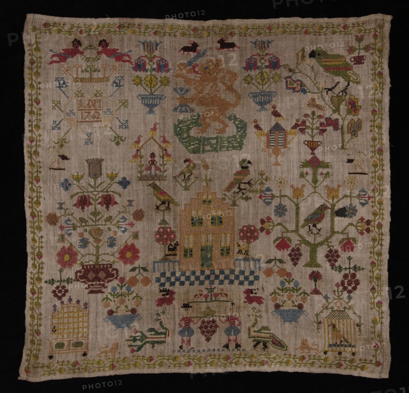 Trademark worked in cross-stitch with colored silk on loosely woven cream-colored linen, IVDM 1762, sampler embroidery