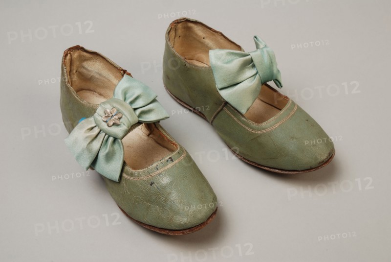 Mint green leather children's shoes with instep strap on which satin bow with decorative button, strap has button closure