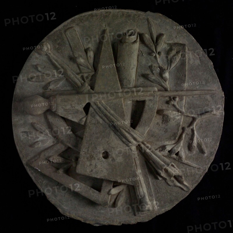 Round plaque with carved masonic symbols: compass, square, triangle and branches with leaves, plaque ornament fragment building