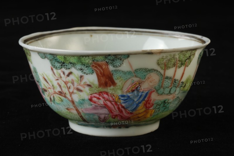 Cup of cup and saucer with lying woman and in bushes hidden man in landscape, cup and saucer drinking utensils tableware holder