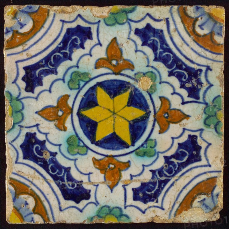 Ornament tile, blue, green, brown and yellow on white, central yellow star in circle, sgraffito surfaces, corner motif, quarter