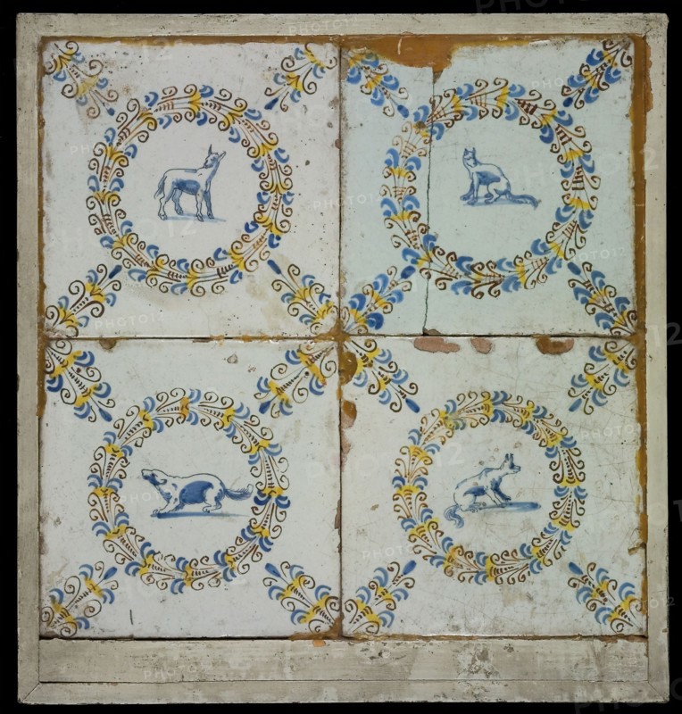 Tile field, four tiles, blue, yellow and brown on white, with goat In aigrettekrans and three times dog in aigrettekrans, corner