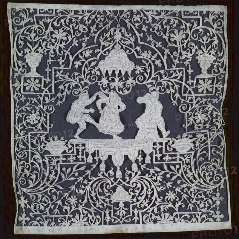 Engraved and carved cutting of white parchment on black ground, with drinking man sitting on barrel and dancing couple, cut art