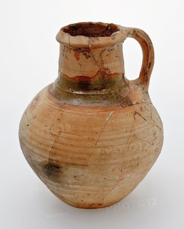 Pottery jug on lens bottom, yellowish shard, green lead glaze on the shoulder, jug crockery holder soil find ceramic earthenware