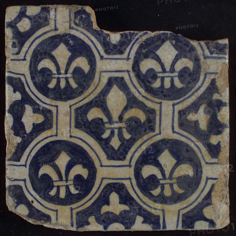 Two-tone tile, blue on white background, four circles with white French lily around central ornament with lily, wall tile