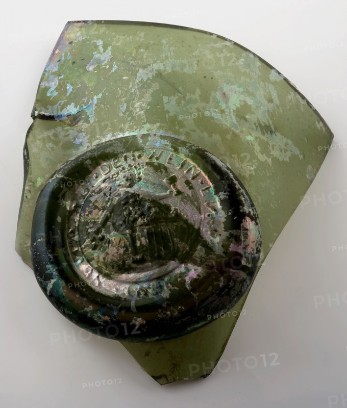 Fragment of the abdominal bottle on which seal with Bacchus on the barrel and round, belly bottle bottle holder soil find glass