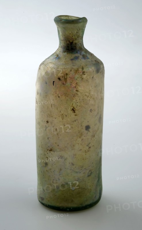 Small cylindrical bottle with round shoulder and slender, short neck, bottle holder soil find glass, free blown Small