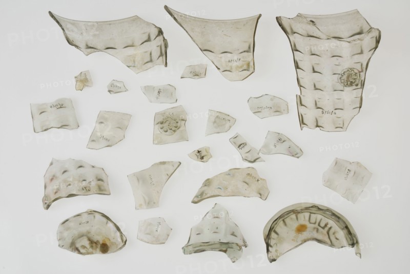 Fragments of soil, stand ring, wall and bramble decoration of waffle cup, beaker tableware holder fragment soil found glass