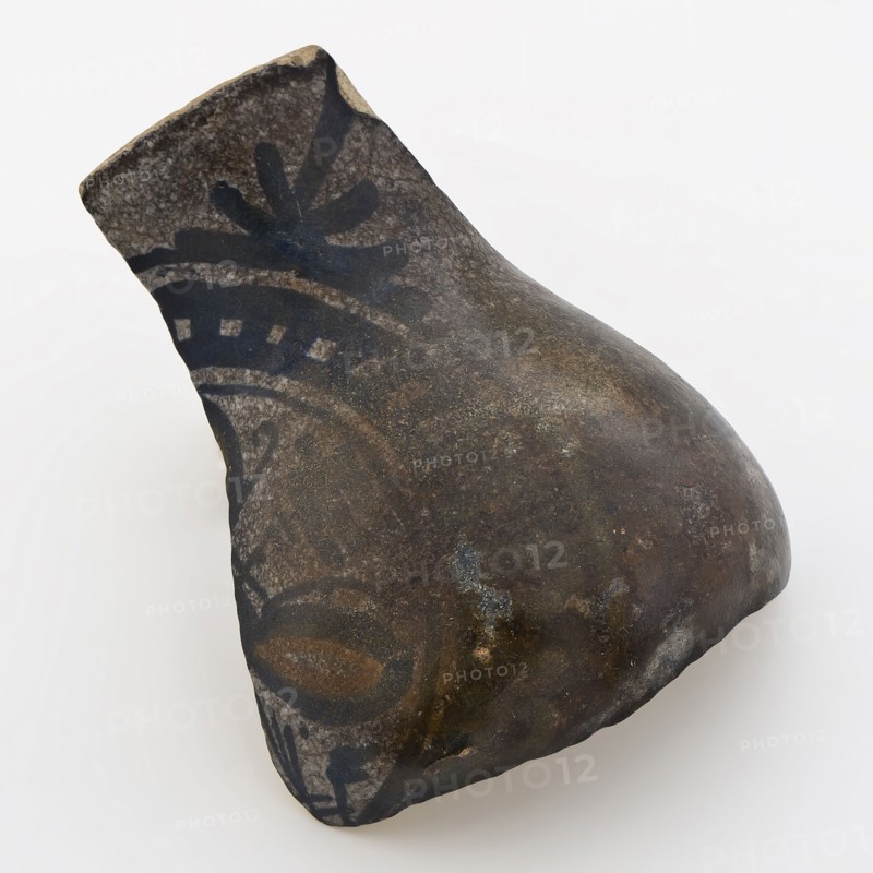 Fragment of majolica jug, pear-shaped model, trifoliate flower as decor, fragment fragile earthenware ceramics pottery glaze tin