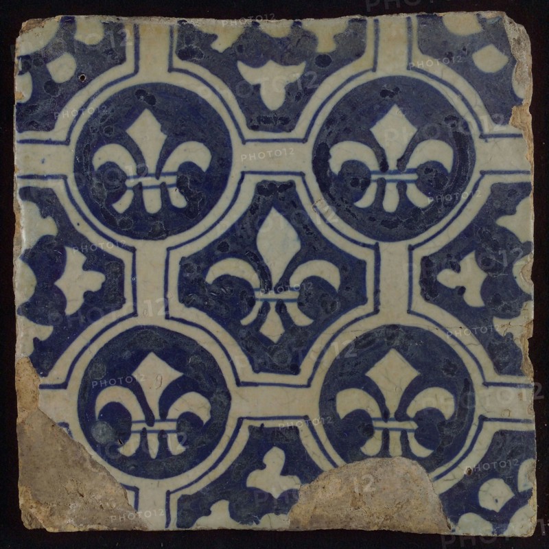 Two-tone tile, blue on white background, four circles with white French lily around central ornament with lily, wall tile