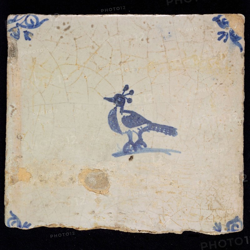 Animal tile with bird, three plumes on the head, blue decor on white ground, corner fill: ox head, marked, wall tile tile image
