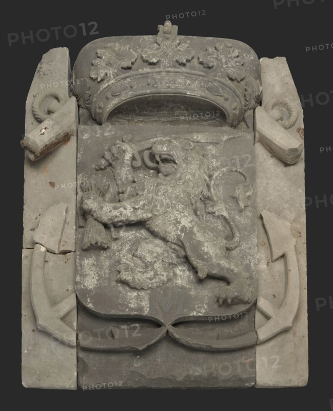 Facade stone in three parts, crowned shield with climbing lion with sword and arrows, on both sides anchors, facing brick