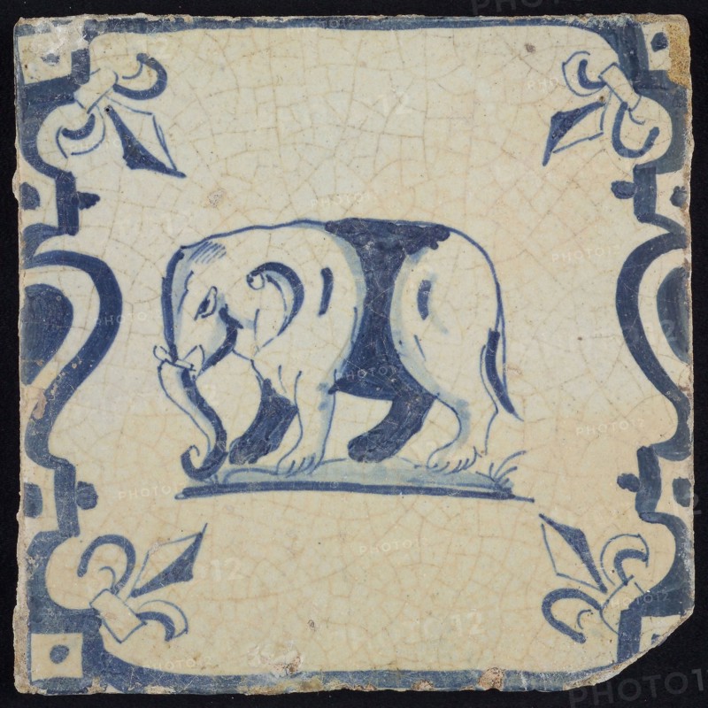 Animal tile, standing elephant frontal on ground between balusters, in blue on white, corner pattern french lily, wall tile