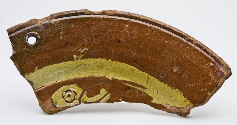 Fragment of earthenware dish on stand fins with bird's head in sludge technology, dish crockery holder soil find ceramic