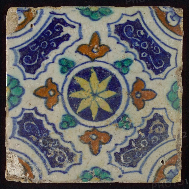 Tile, blue, green, brown and yellow on white, central yellow star in circle, sgraffito surfaces, corner motif, quarter rosette