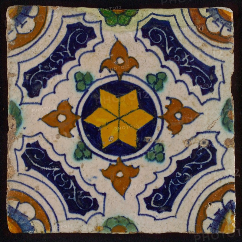 Tile, blue, green, brown and yellow on white, central yellow star in circle, sgraffito surfaces, corner motif, quarter rosette