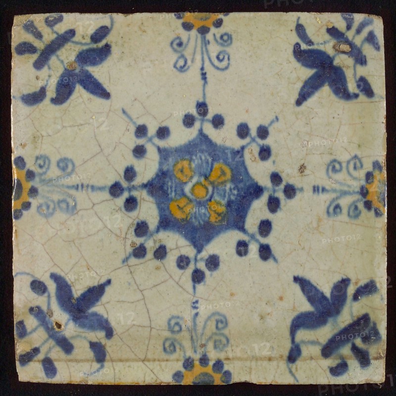 Tile, blue pull and orange on white, central flower within star shape, three-piece around, half rosette, corner pattern lily