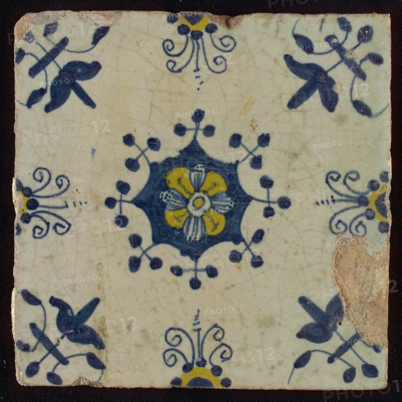 Tile, blue draft and yellow on white, central flower within star shape, three-spot around, half rosette, corner pattern lily