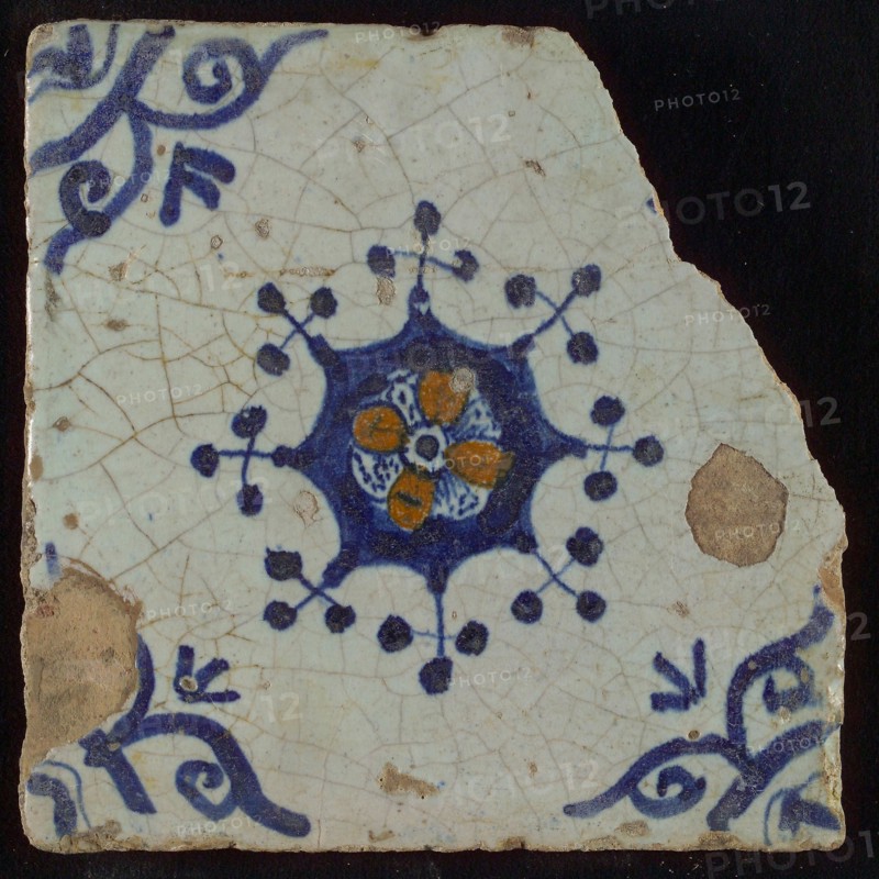 Tile, blue draft and orange on white, centrally flower within star shape, three-spot around, corner pattern ossenkop, wall tile