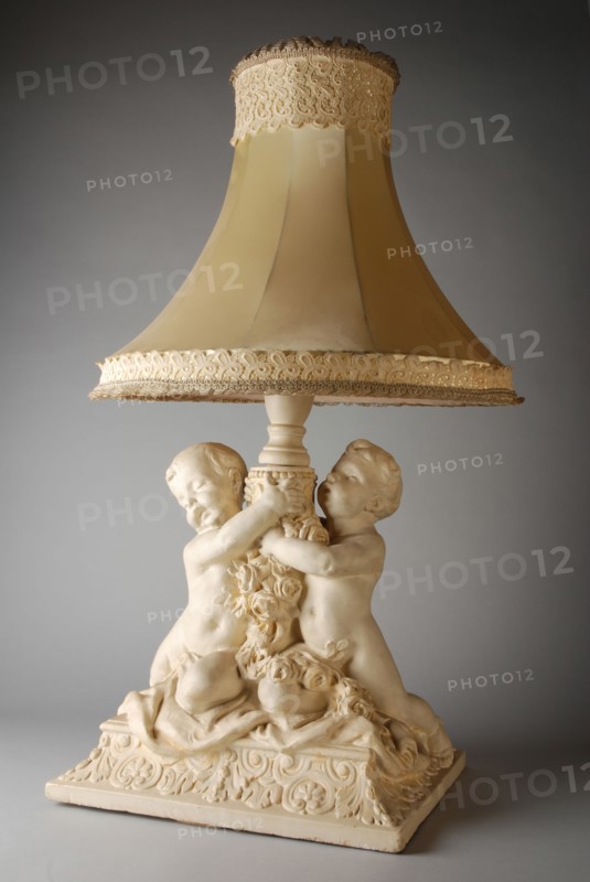 Simon Miedema, White table lamp, with decorated plaster foot of two putti and lampshade trimmed with lace, table lamp lamp