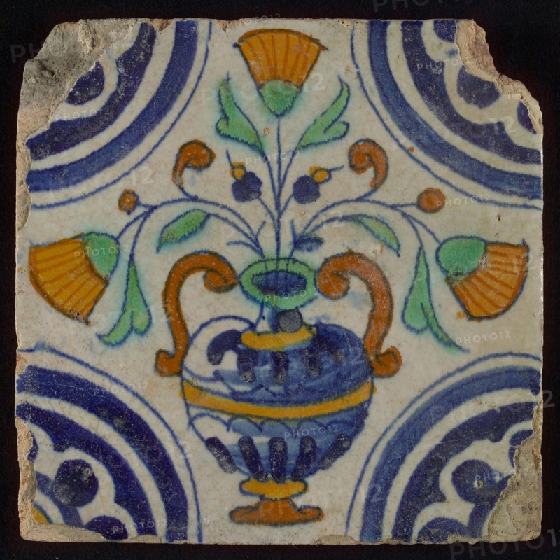 Tile, blue draft, orange, yellow, brown and green on white, central flowerpot with marigolds, corner pattern, rosette, wall tile
