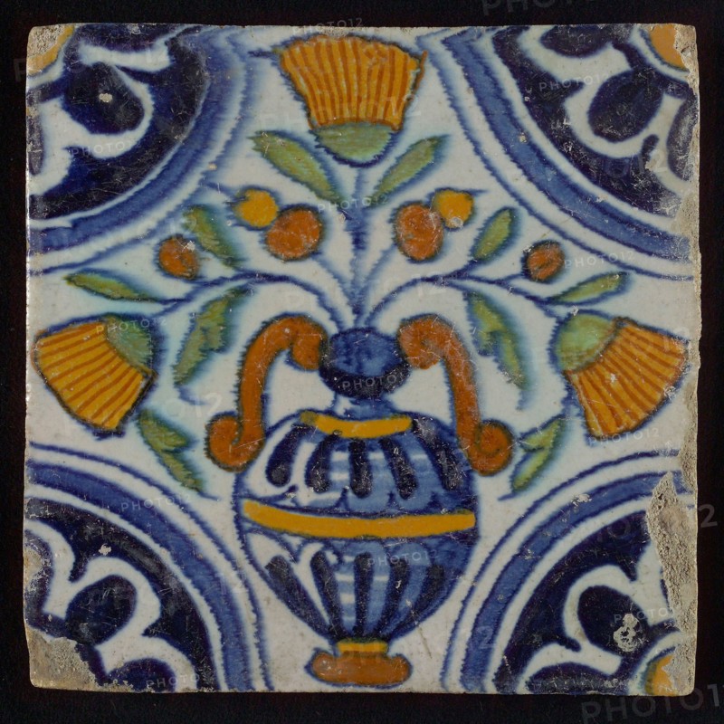 Tile, blue draft, orange, brown, yellow and green on white, central flowerpot with marigolds, corner pattern, rosette, wall tile