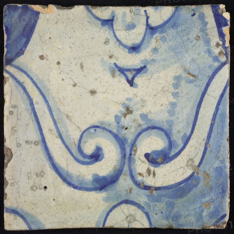 Tile of chimney pilaster, blue on white, part of column with curly ornament with stylized belly button, chimney pilaster tile