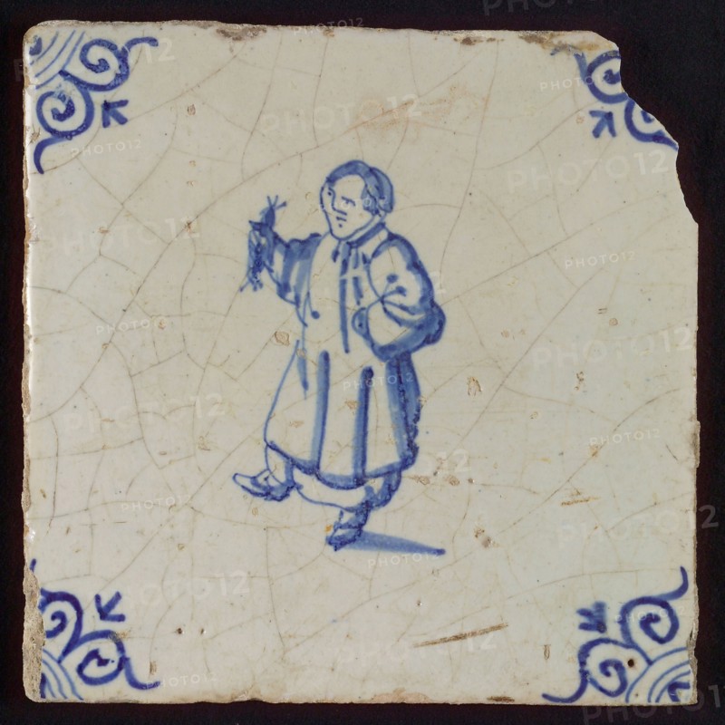 Scene tile, figure with nut mill, Corner motif oxen head, wall tile tile sculpture ceramic earthenware glaze, baked 2x glazed