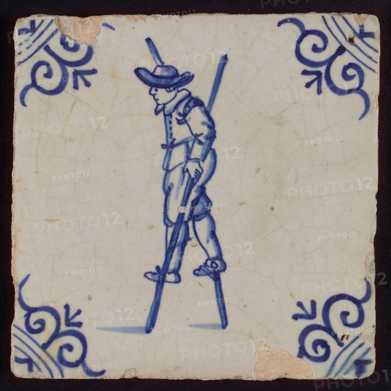 Scene tile, child's play, child with stilts, corner motif ox's head, wall tile tile sculpture ceramic earthenware glaze tin