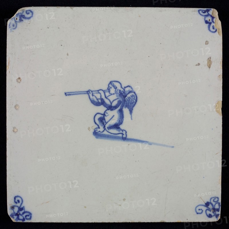 White tile with blue kneeling putto with wind instrument, corner motif spider, wall tile tile sculpture ceramic earthenware