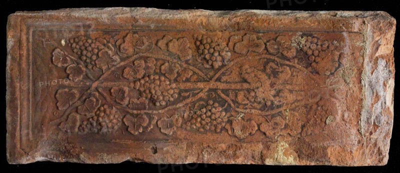 Stone with smooth wine list, vine with bunches of grapes, stone building element ceramics brick, baked Stone