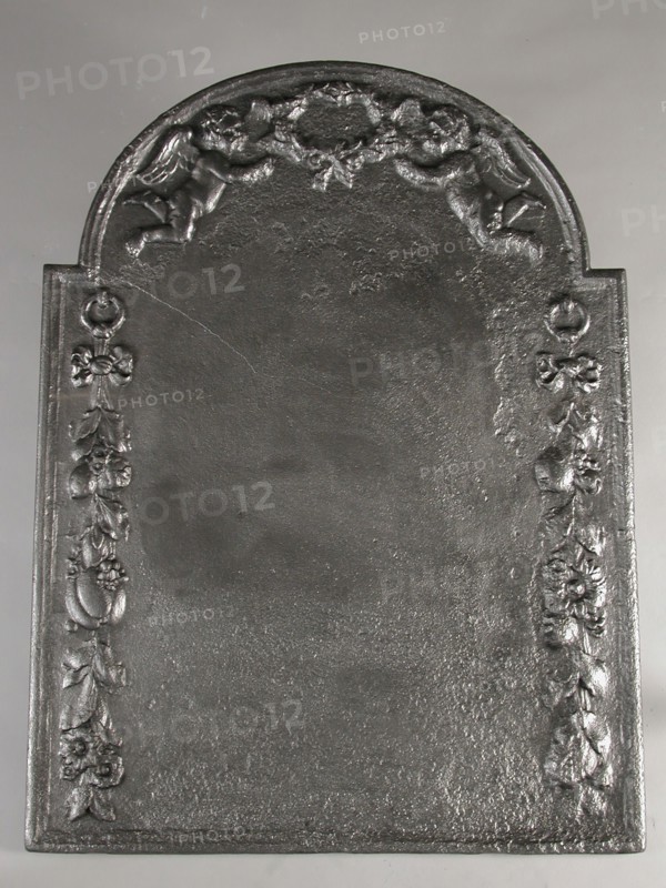 Fireback putti with laurel wreath and fruit-eaters, fire place, cast Rectangular arch at the top. In the arch two putti holding