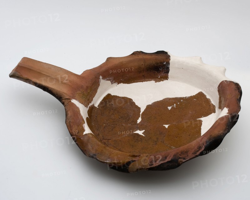 Earthenware baking pan on curved bottom with lobed edge and handle as handle, casserole tableware holder kitchen utensils