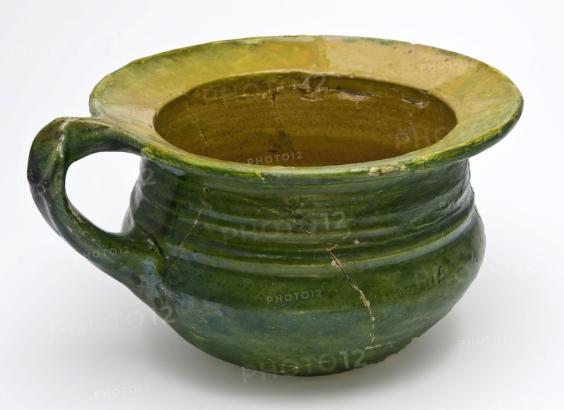 Green chamber pot with curved bottom, standing ear and wide flat edge, yellow and green glaze, pot holder sanitary soil found