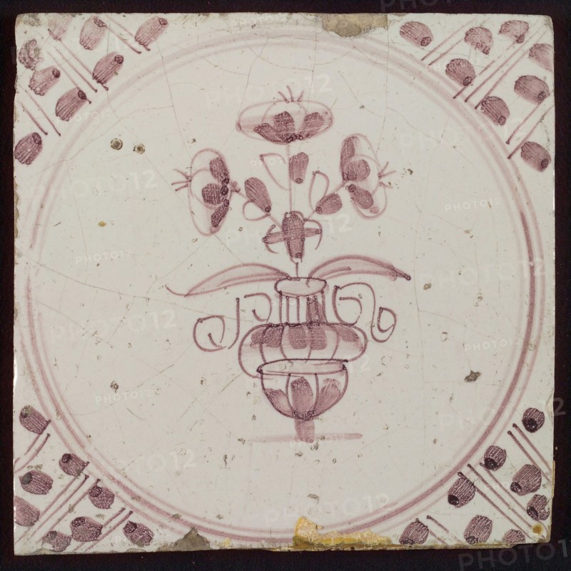 White tile with purple small flowerpot in circle frame with meanders, wall tile tile sculpture ceramic earthenware glaze, baked